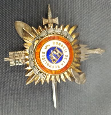 un insigne orné d'une étoile sur un fond gris