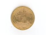a gold coin with a eagle on it on a white surface