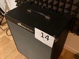 a black amp sitting on the floor in front of a wall