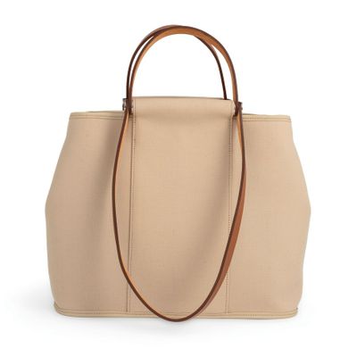 un sac à main beige avec une poignée marron sur fond blanc