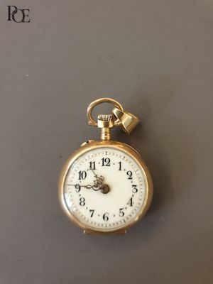 une montre de poche en or à laquelle est suspendue une chaîne sur le côté