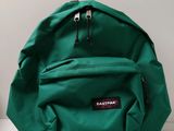 a close up of a green backpack sitting on a white surface