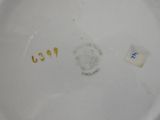 a close up of a white plate with a gold emblem on it