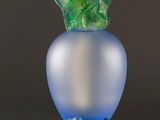 a glass vase with a green leaf decoration on it