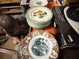 a boy that is looking at some plates on a table