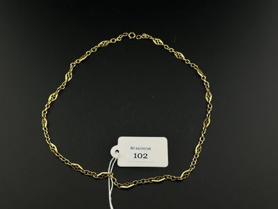 a close up of a gold chain bracelet with a tag on it
