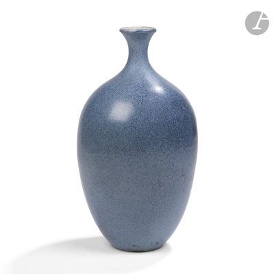 un vase bleu posé sur une surface blanche