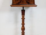 an antique wooden music stand with a wooden top and a wooden base