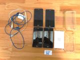 several cell phones are sitting on a table next to a charger
