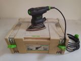 une ponceuse électrique posée sur une boîte, avec son cordon d'alimentation