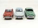 three toy cars sitting side by side on a white surface