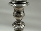 a silver candle holder on a table with a white background