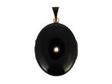une image représentant un pendentif en pierre noire orné d'une perle au centre