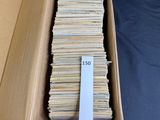 an open cardboard box filled with lots of books on a blue surface