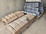 un tas de bois posé sur une palette devant un mur
