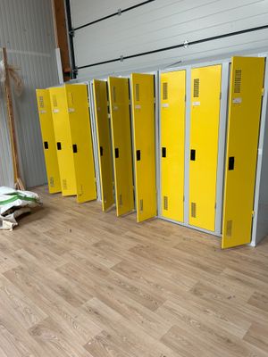 Plusieurs casiers jaunes sont alignés en rangée dans un entrepôt