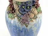 a blue vase with a bunch of grapes on it