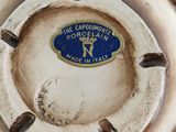 a close up of a porcelain vase with a blue and white label on it