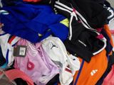 a pile of clothing that is on a bed