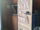 a small refrigerator with a door open and a cover on it