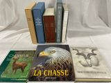 plusieurs livres posés sur une table recouverte d'une nappe blanche, sur fond blanc