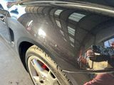 un homme en train de prendre une photo de son reflet sur la vitre arrière d'une voiture