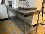 a person standing in a kitchen with a large table