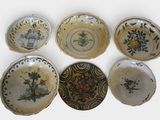 several different types of decorative plates are arranged on a white surface