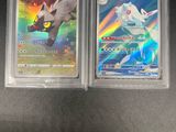 Deux cartes Pokémon sont posées sur une table avec un fond noir.