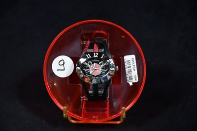 une montre dans un écrin rouge posée sur un fond noir