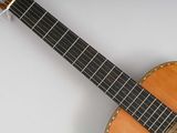a close up of an acoustic guitar on a white surface