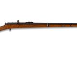 un fusil avec un canon en bois sur fond blanc