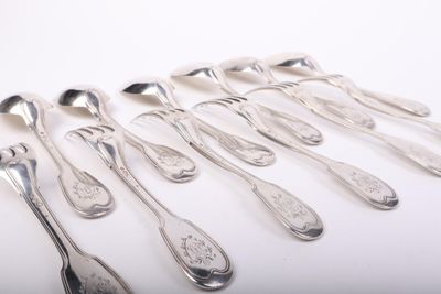 six cuillères et deux cuillères en argent sur une surface blanche