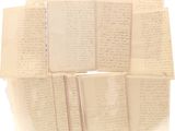une pile de vieux papiers couverts d'écriture, posée sur une surface blanche