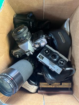une boîte en carton remplie d'appareils photo et de quelques objectifs