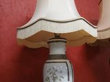 two lamps sitting on a table with a red wall in the background