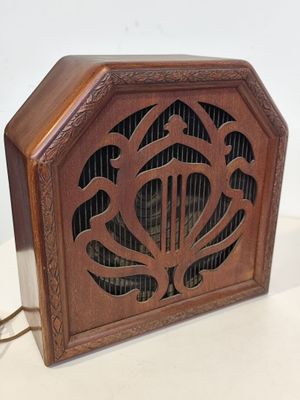 une vieille radio en bois surmontée d'un oiseau
