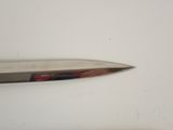 a knife that is laying on a white surface