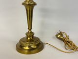 an image of a gold colored lamp with a cord attached to it