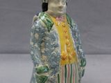 a ceramic figurine of a man in a suit and tie