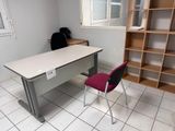 un bureau avec une chaise et une étagère dans le coin