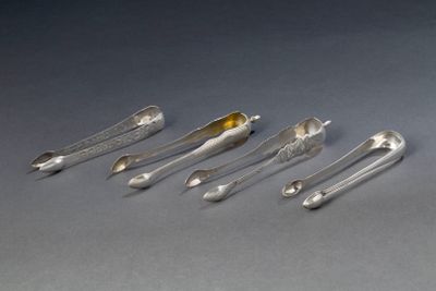 six cuillères en argent et deux cuillères en argent posées sur une surface grise