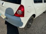 une petite voiture blanche garée sur le bord de la route