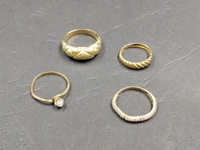 three gold rings and a ring with a stone in the middle