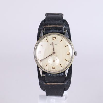 a close up of a wrist watch on a white surface