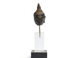 une image représentant une statue représentant une tête de Bouddha posée sur un socle transparent