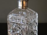 a small glass bottle with a silver lid on a table