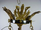 a gold chandelier with a bird and flowers on it