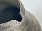 a gray vase that is sitting on a table