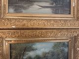 two framed paintings of boats on a river with trees in the background